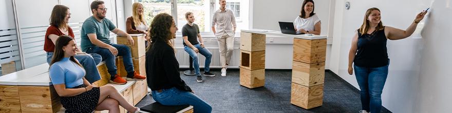 Die Azubis bekommen von den beiden Ausbilderinnen etwas am Whiteboard erklärt.