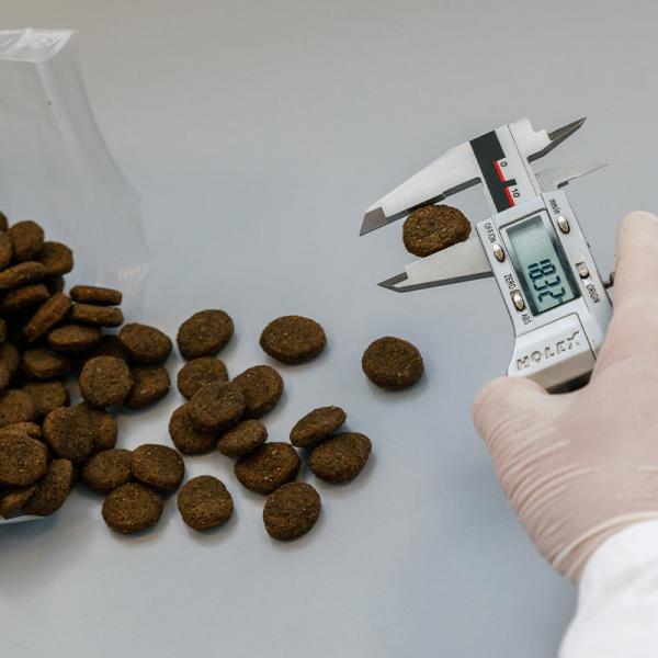 Der Durchmesser der Hundefutter Kroketten wird geprüft.